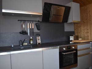 a kitchen with white cabinets and a black counter top at Chalet individuel plein sud avec suites parentales, garage et équipements modernes – 8 pers. max - FR-1-580-111 in Font Romeu Odeillo Via