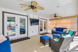 salon z niebieskimi meblami i wentylatorem sufitowym w obiekcie Luxe Jupiter Home with Pool House, Near Golf and Beach w mieście Jupiter