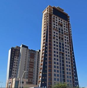 a tall building in front of some tall buildings at Room 50Two, Itower Apartment, CBD, Gaborone in Gaborone