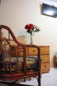 einen Stuhl mit einer Blumenvase auf einer Kommode in der Unterkunft Hotel Toledo in David