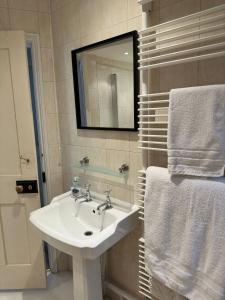 a bathroom with a sink and a mirror and towels at Tower House, Cowes Old Town in Cowes +29 photos