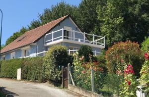 una casa con una valla y flores delante de ella en La Falaise Bleue - Vue mer - Plage à pied, en Veules-les-Roses
