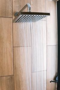 een douche met een douchekop op een houten muur bij Luxury 3BR Oceanfront Retreat - Pool, Views & Private Beach Access in Chicxulub +16 foto's