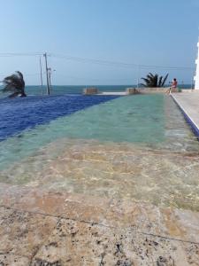 a pool of clear blue water next to the ocean at Hospedaje,Cartagena,Terraza San Sebastián in Cartagena de Indias