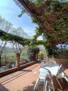 un patio con una mesa y sillas blancas y una valla en Casa Serafina trilocale con arredi d'arte e parcheggio privato, en Orvieto