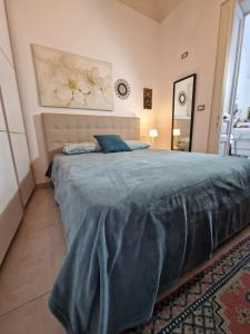a bedroom with a large bed with a blue blanket at Elvira Home in Catania
