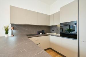 a kitchen with white cabinets and a counter top at Luxury Design Suite - 20 minutes from DUOMO-NAVIGLI in Milan