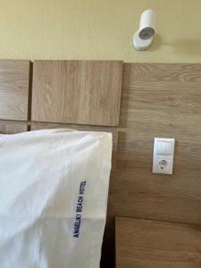 a room with a bed and a lightswitch and a bed sidx sidx at Angeliki Beach Hotel in Megali Ammos