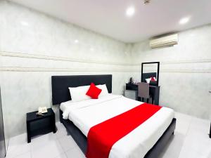 Schlafzimmer mit einem roten und weißen Bett und einem Spiegel in der Unterkunft Centara Saigon Hotel - 270 Ly Tu Trong in Ho-Chi-Minh-Stadt