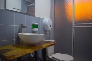 a bathroom with a bowl sink and a toilet at FILANDIA HOTEL in Filandia