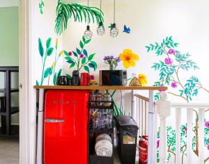a room with a red refrigerator and flowers on the wall at Botanic Rooms in Liverpool