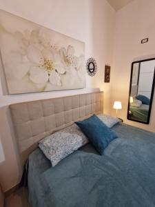 a bedroom with a bed with a blue pillow and a mirror at Elvira Home in Catania