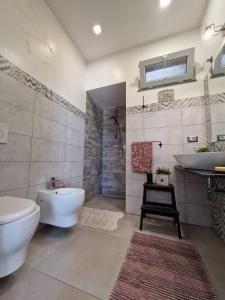 a bathroom with a tub and a sink and a toilet at Elvira Home in Catania
