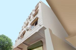 OYO Flagship Delightful Stay Em Byepass Near Birla Mandir في Tangra: مبنى أبيض مع نافذة وشرفة