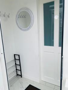 a white door in a room with a mirror at New Malden, 3 Bedroom Guest House in Malden