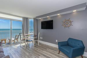 a living room with a blue chair and a dining room at Oceanfront One Bedroom Suite-Atlantica 803 in Myrtle Beach