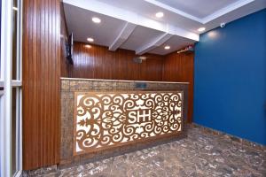 um átrio com uma parede com uma tela decorativa em OYO Stay hub park street em Calcutá