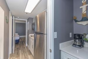 a kitchen with a stainless steel refrigerator in a room at Oceanfront One Bedroom Suite-Atlantica 803 in Myrtle Beach