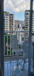 a table and chairs on a balcony with a view of a city at Duplex Impression Morumbi in Sao Paulo