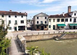 a group of buildings next to a river at dimora scaldaferro in Mira