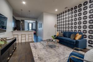 a living room with a blue couch and a kitchen at Lofts at 30th - 2 Top Floor Units in Nashville