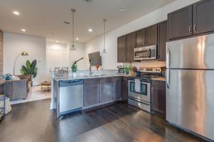 a kitchen with stainless steel appliances and wooden cabinets at Lofts at 30th - 2 Top Floor Units in Nashville