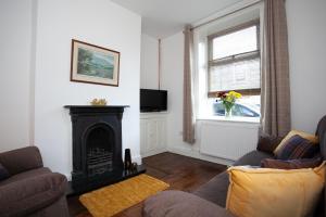 a living room with a fireplace and a tv at Spacious 3 bedroom Cottage in Whalley in Whalley