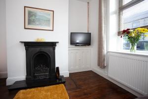 uma sala de estar com lareira e televisão em Spacious 3 bedroom Cottage in Whalley em Whalley