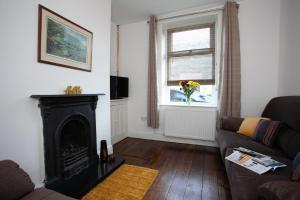 uma sala de estar com lareira e sofá em Spacious 3 bedroom Cottage in Whalley em Whalley