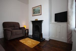 a living room with a chair and a fireplace at Spacious 3 bedroom Cottage in Whalley in Whalley