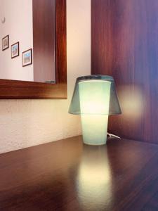 una lámpara sobre una mesa de madera en Casa Melany, en Taormina