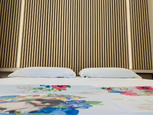 Una cama con dos almohadas encima. en Casa Melany, en Taormina