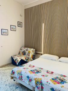 a bedroom with two beds and a chair at Casa Melany in Taormina