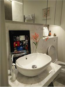 a bathroom with a white sink and a toilet at Private room in luxury canary wharf apartment in London