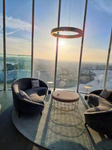 a room with two chairs and a table in a building at Private room in luxury canary wharf apartment in London