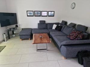uma sala de estar com um sofá e uma mesa em Ferienhaus an der Brunnenaue 4 Sterne zertifiziert kostenlos Wlan & Netflix em Sagard