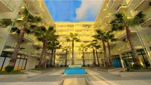 a large building with palm trees in front of it at King Princ in Shëngjin