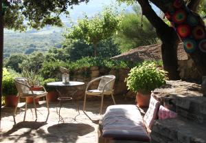 a patio with two chairs and a table and a table and chairs at Casa Christa in Alfarnate