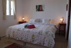 a bedroom with a bed with a white comforter at Casa Christa in Alfarnate