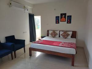 a bedroom with a bed and a blue chair at Friendlystay Prime in Chennai