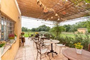 an outdoor patio with tables and chairs and a pergola at Mas Coquells Rural - Habitació doble amb bany i terrassa privada in Vilanant +5 photos