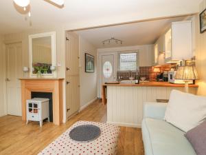 Il comprend un salon avec un canapé et une cuisine. dans l'établissement Mulberry Cabin On The Lake, à Caernarfon
