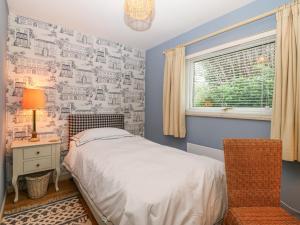 - une chambre avec un lit, un bureau et une fenêtre dans l'établissement Mulberry Cabin On The Lake, à Caernarfon