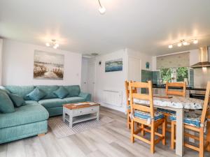 een woonkamer met een bank en een tafel bij Blue Sky Cottage in Liskeard