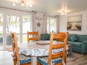 een eetkamer met een tafel, stoelen en een bank bij Blue Sky Cottage in Liskeard +11 foto's