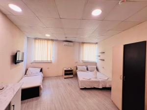 a hospital room with two beds and a tv at Highland Holiday Home Hostel in Yerevan