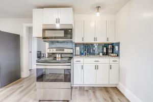 a kitchen with white cabinets and a stove at Weymouth Apartment Close to Beaches and Boston! in Weymouth