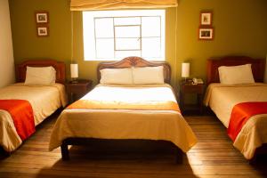 a bedroom with two beds and a window at Casa Bonita Colonial in Cajamarca