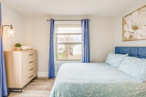 a bedroom with a bed and a window with blue curtains at Weymouth Apartment Close to Beaches and Boston! in Weymouth