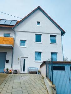 une maison blanche avec des fenêtres bleues et une allée. dans l'établissement Authi's Charmante Stube, à Kirchheim unter Teck